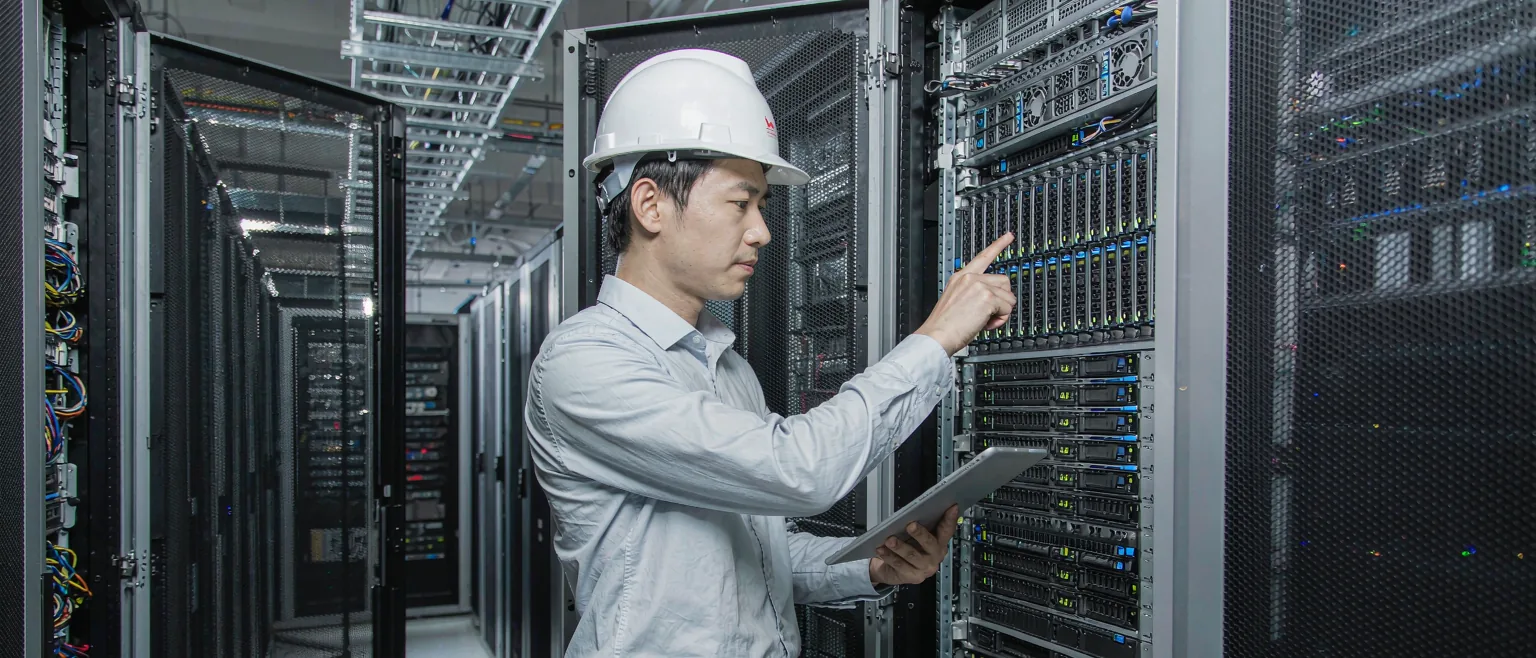 中国数据中心的中国工程师在服务器机柜前巡检,机柜指示灯密集闪烁