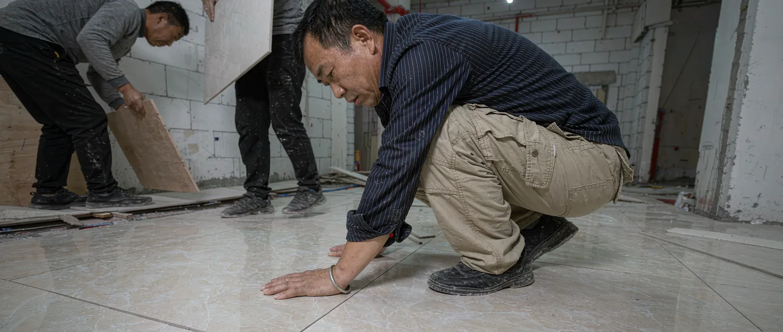 中国家装项目经理在工地对照图纸检查工序进度并拍照