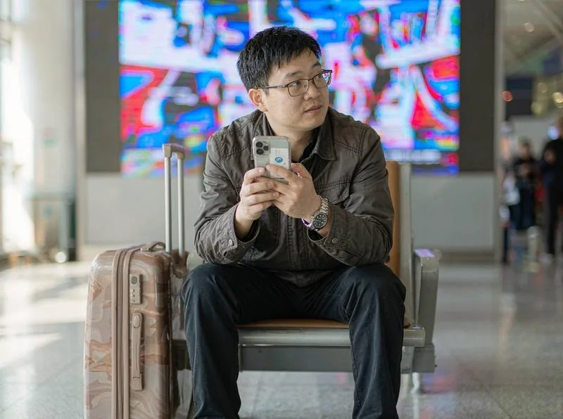 中国企业的员工在手机上提交差旅报销单并上传发票