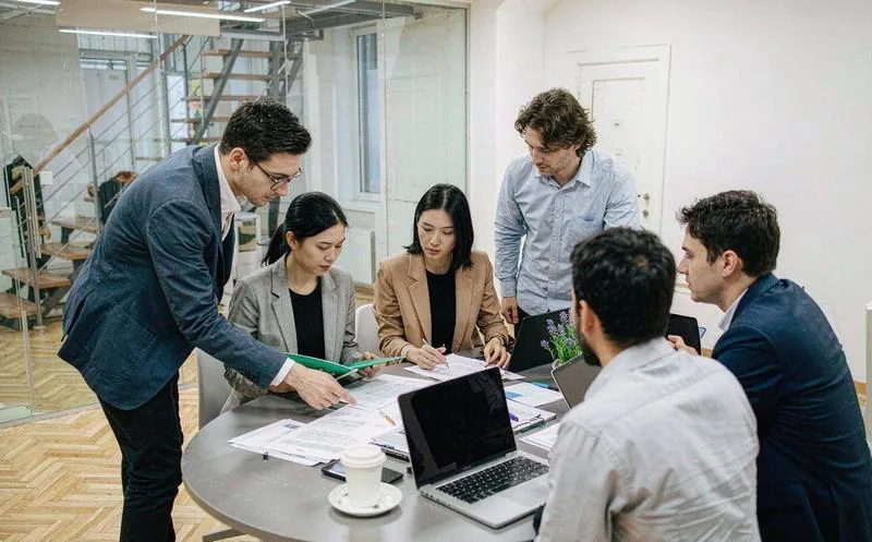 中国企业中会议室,一名行政人员在笔记本上处理审批流转,投影显示流程看板