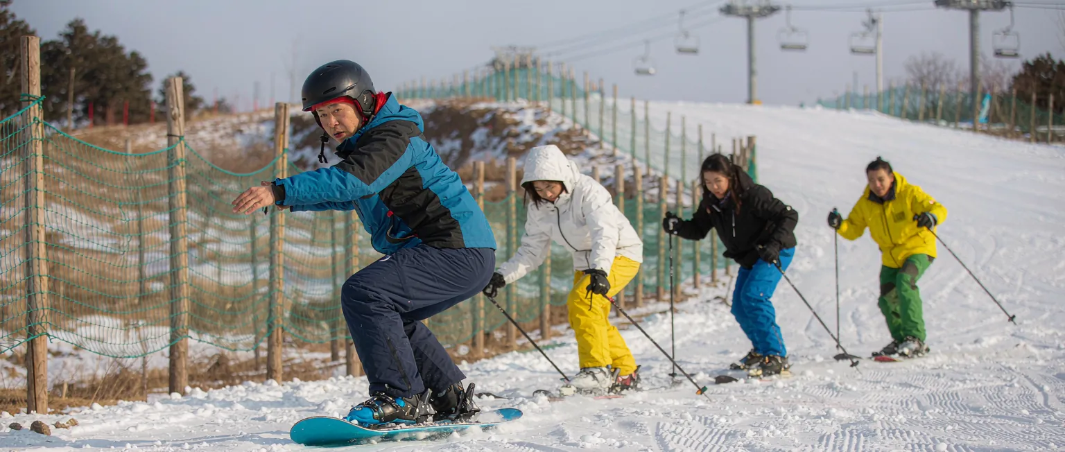 中国滑雪场游客在闸机前扫码入园,身后雪具租赁区整齐摆放雪板雪鞋护具